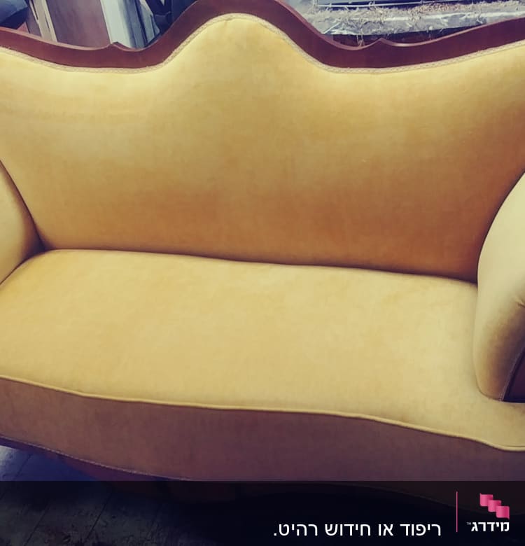 ספה מרופדת בבד צהוב עם מסגרת עץ כהה